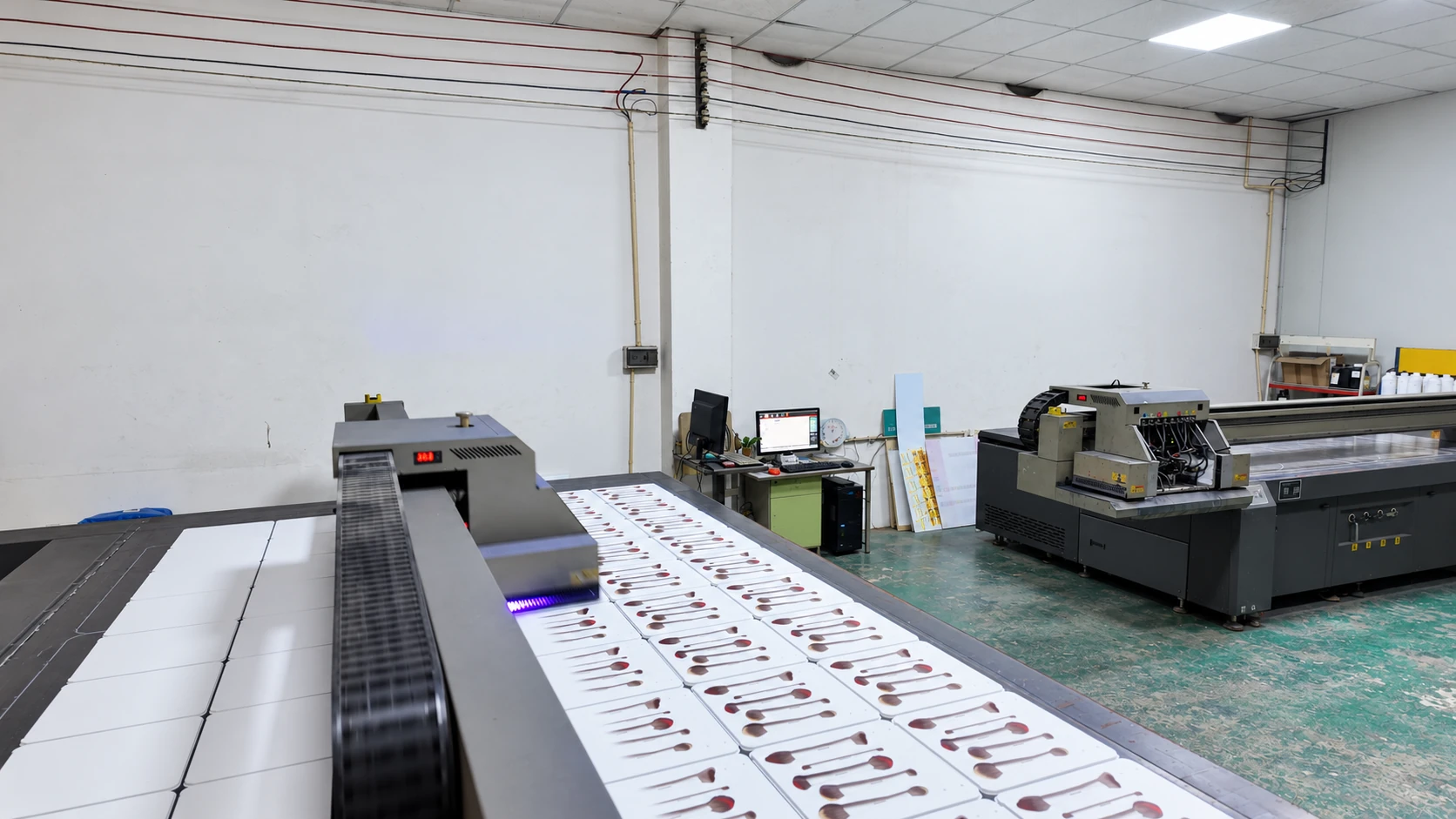 UV flatbed printers with printed white panels in a graphics production workshop