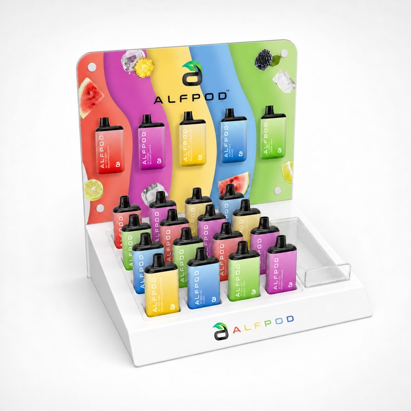 Partially stocked white acrylic countertop vape device display with product slots, a raised header and a side tray, left front view.